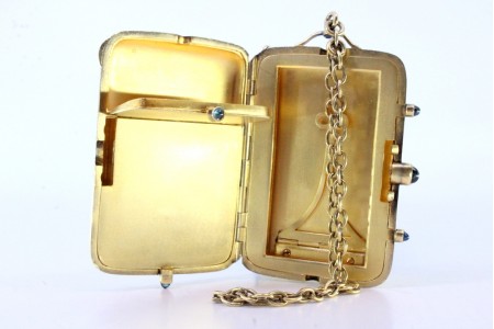 Caixa de toilette em prata dourada com frisos ao alto e duas divisórias no interior, ornamentado com cinco cabochões de cor azul e corrente em malha cadeado.